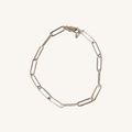 A silver paperclip chain bracelet, displayed on a light cream background.