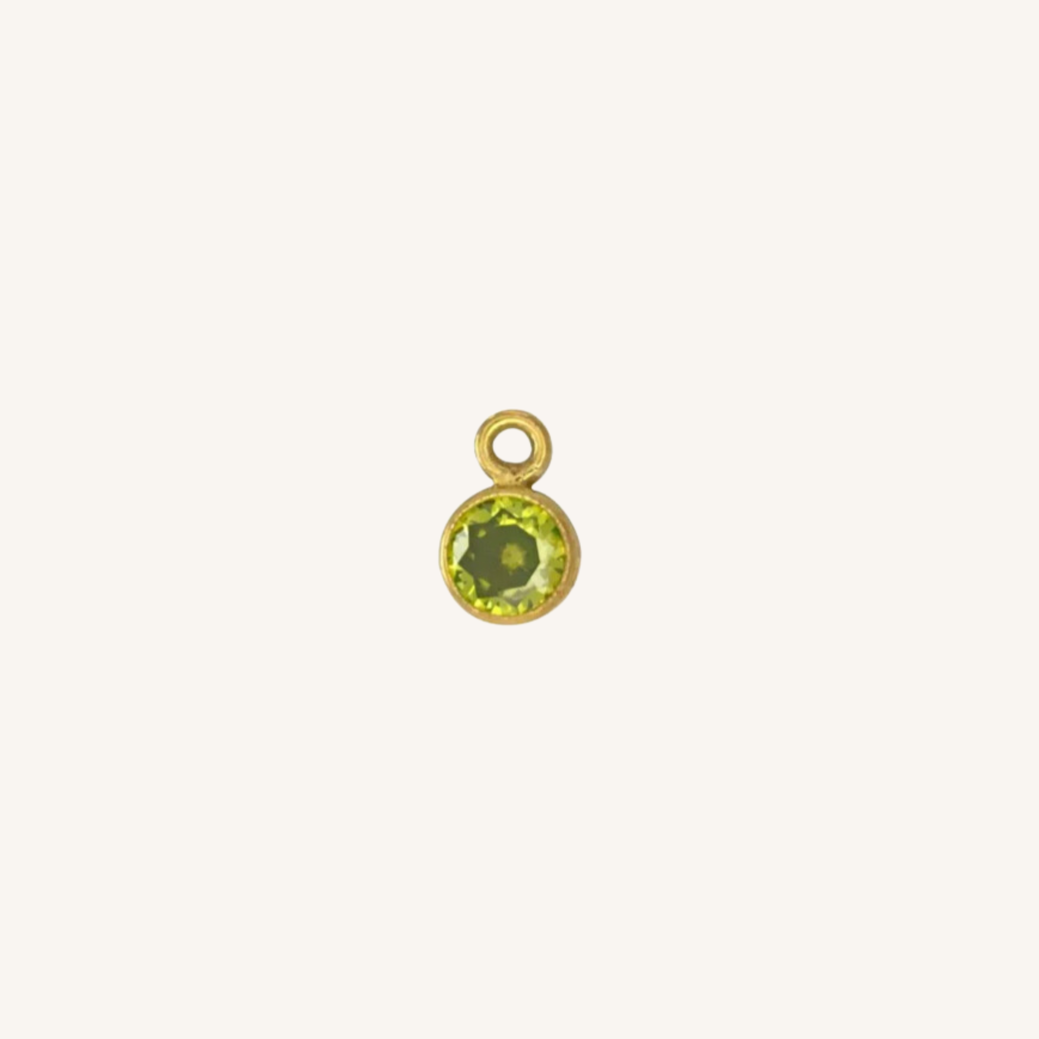 Round peridot charm in gold.