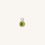 A small round peridot charm in silver, centered on a light cream background.