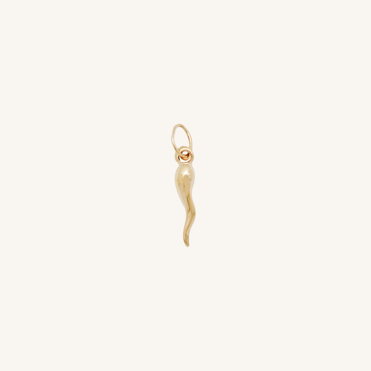 Chilli charm in gold on white background.
