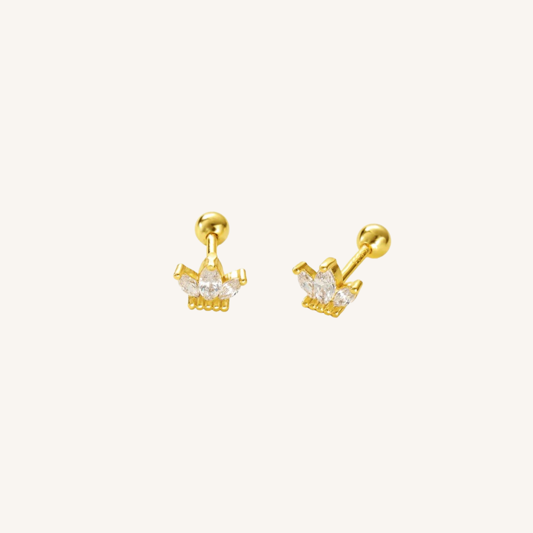 A pair of gold crown stud earrings with clear marquise-cut gemstones, shown from both front and side angles on a light cream background.