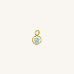 Round turquoise charm in gold on white background.
