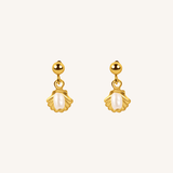 A pair of gold dangle earrings with scallop-shaped gold settings holding white pearl-like drops, shown on a plain off-white background.