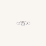 A silver eye-shaped charm with a clear rhinestone in the center, set against a solid off-white background.