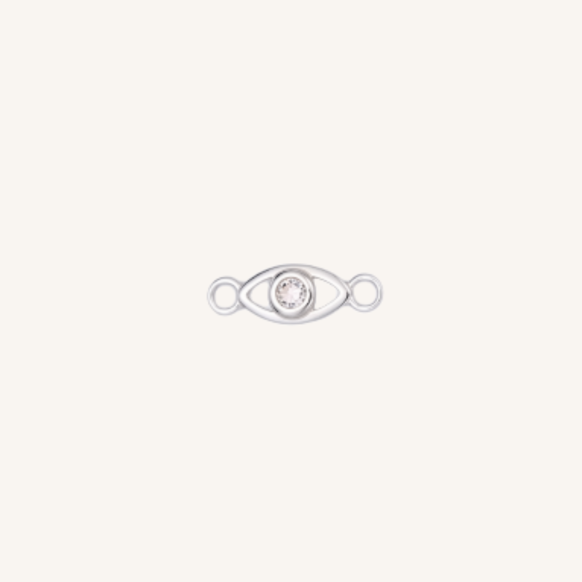 A silver eye-shaped charm with a clear rhinestone in the center, set against a solid off-white background.