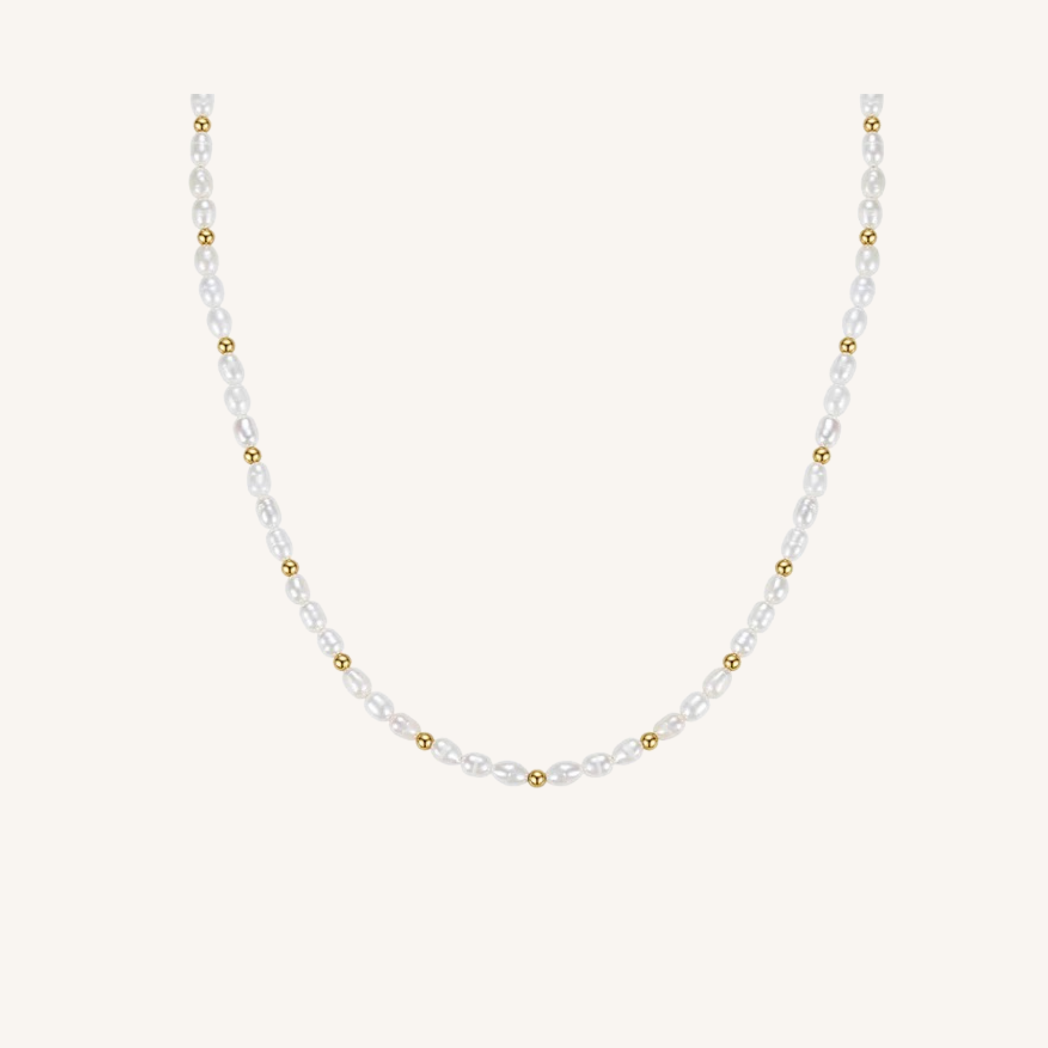 A delicate necklace featuring faceted white pearls and small gold spacer beads, arranged in a U-shape against a solid off-white background.
