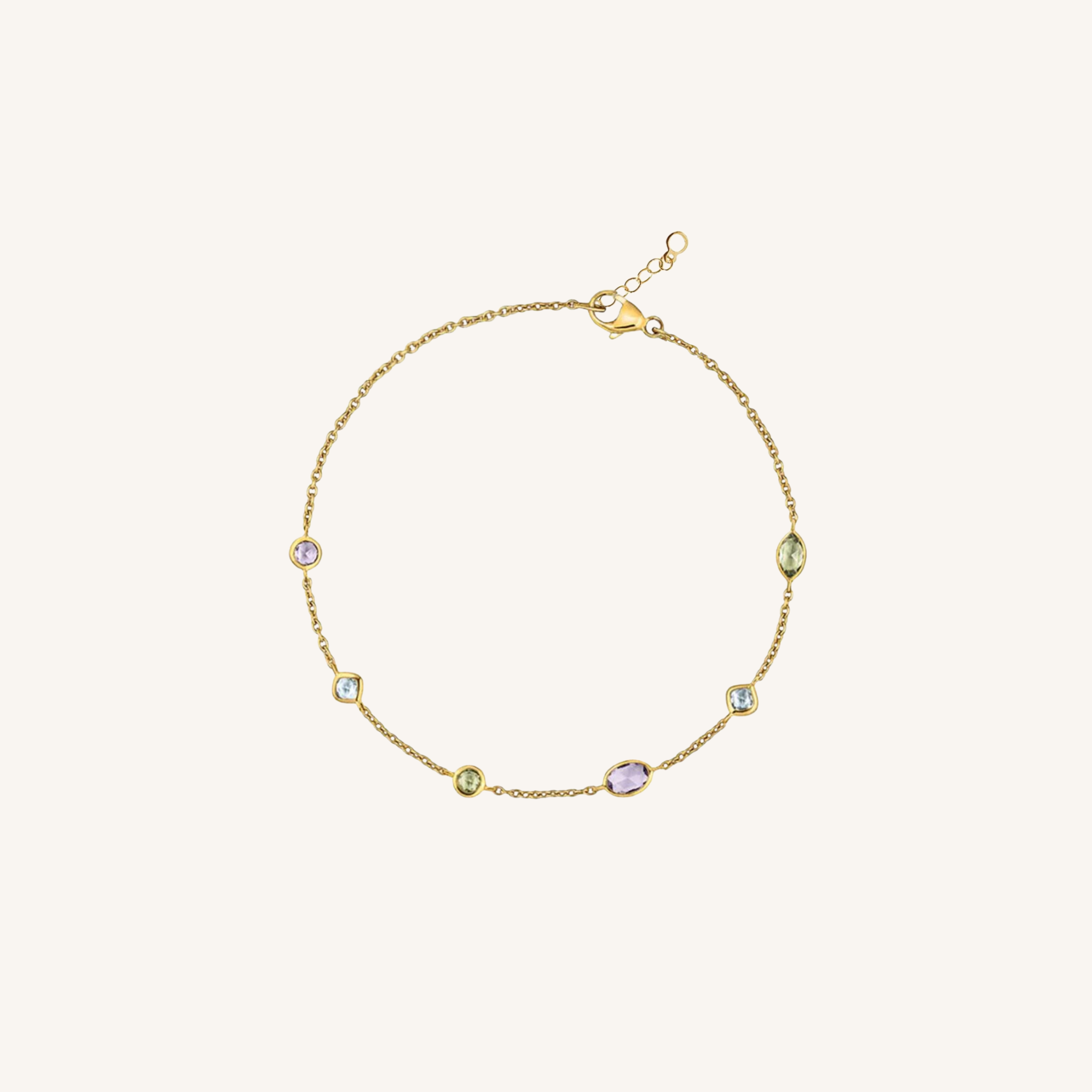 A delicate gold chain bracelet with five small oval and round stones in pastel shades of green, lavender, and light blue, displayed on a clean off-white background.