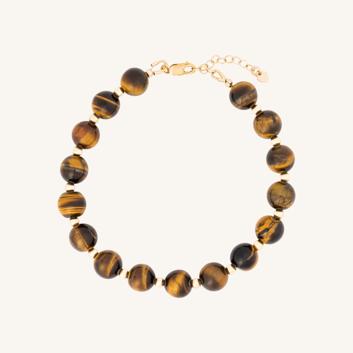 A beaded bracelet made of polished tiger's eye beads with gold spacer rings and a gold clasp, displayed on a light cream background.