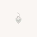 Silver heart charm on white background.