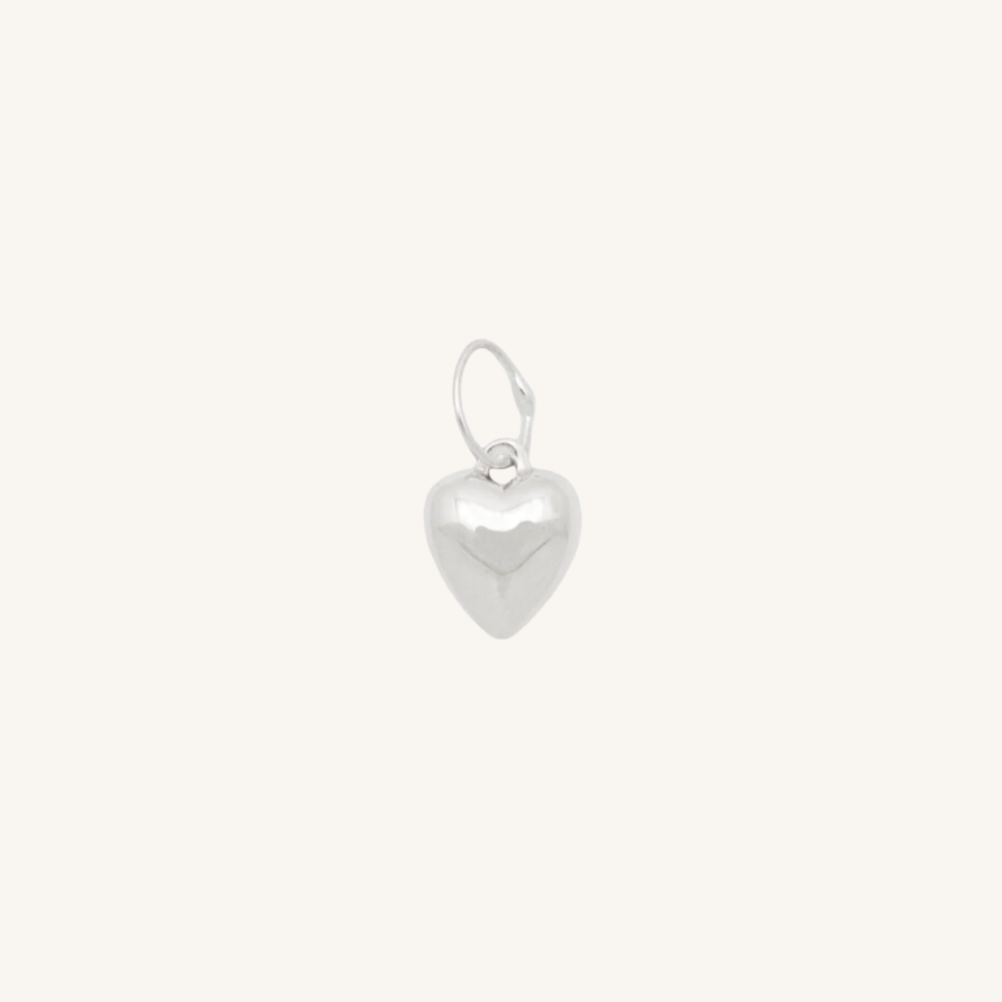 Silver heart charm on white background.