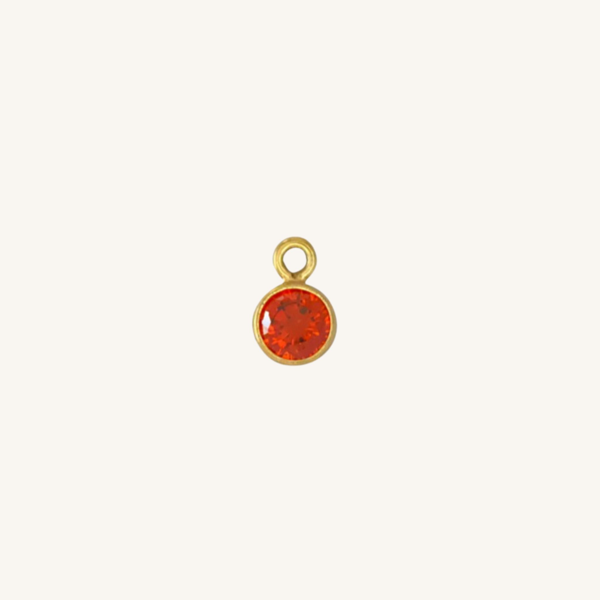 Round garnet charm in gold.