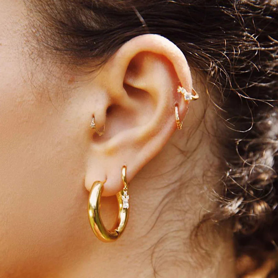 Model wearing Jessica Hoop Earrings in the gold clear style.