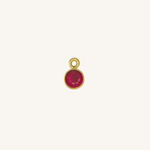Round ruby charm in gold.