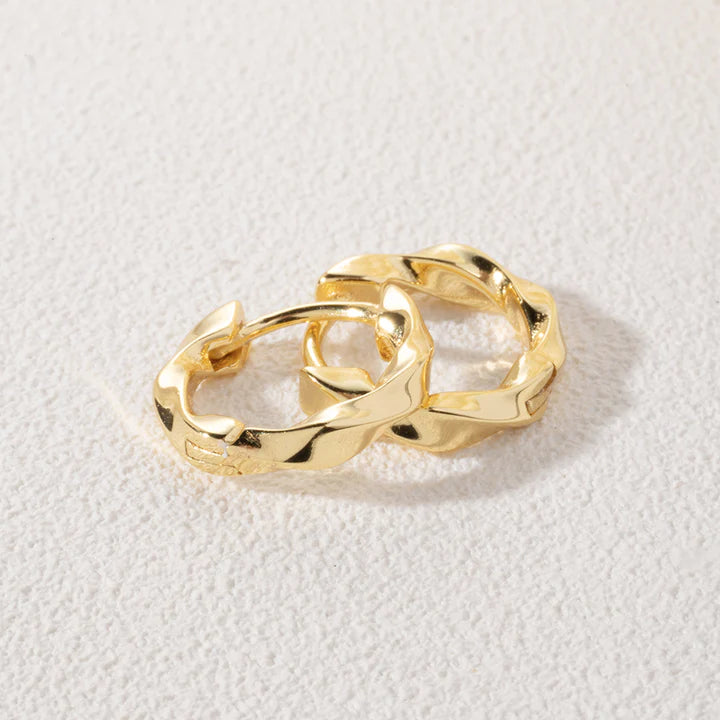 Leanne Twisted Hoop Earrings in gold on neutral background.