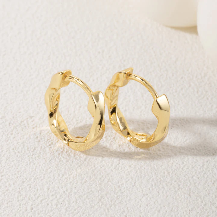 Leanne Twisted Hoop Earrings in gold on neutral background.