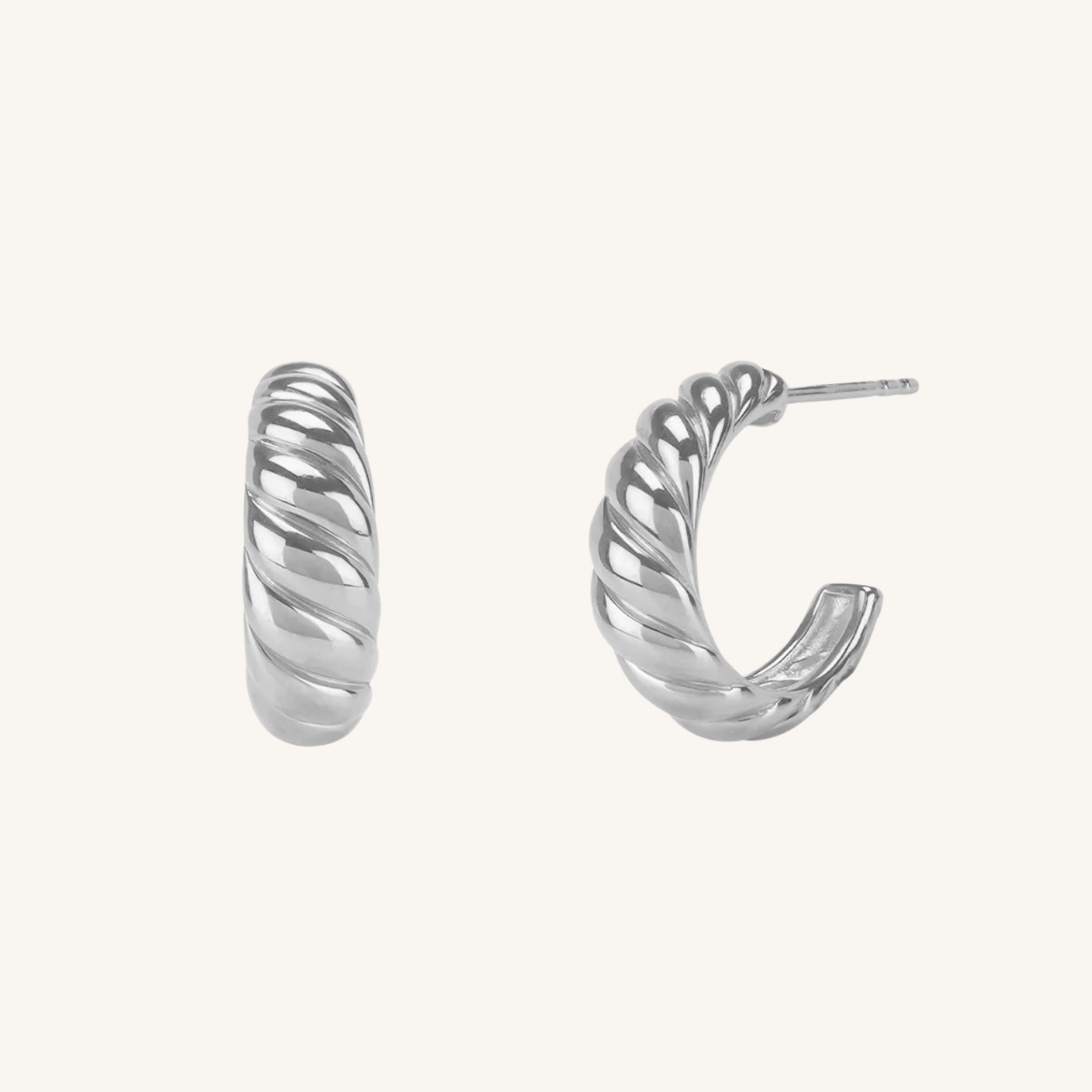 A pair of silver twisted hoop earrings shown on a plain off-white background, with one earring facing forward and the other angled to show the side profile and post.
