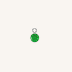 A small round emerald charm in silver, centered on a light cream background.