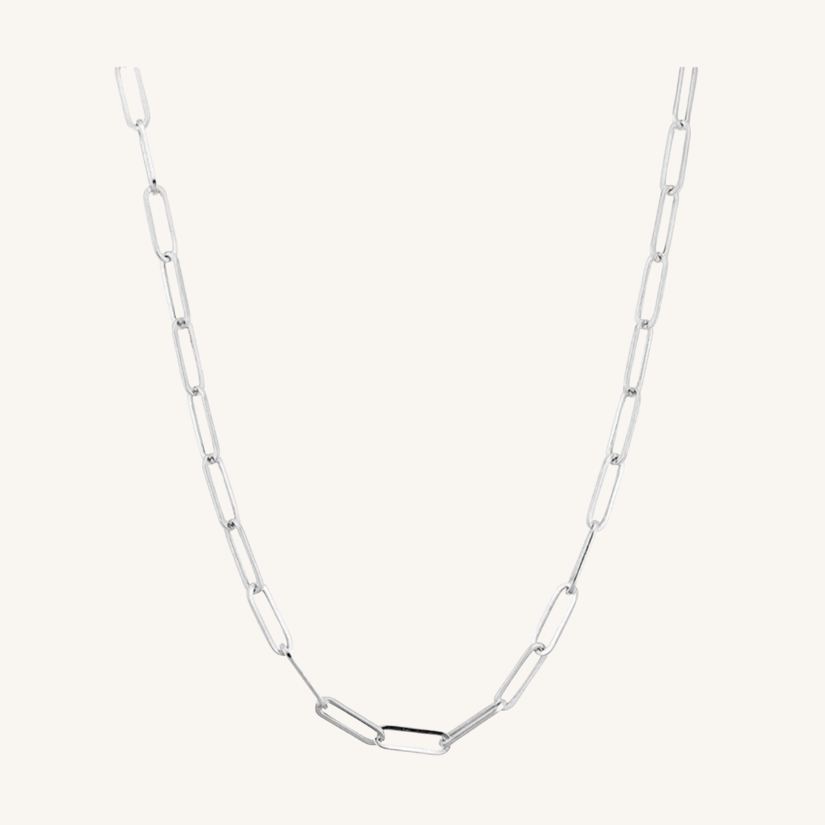 A silver paperclip chain necklace with elongated oval links, displayed against a solid off-white background.