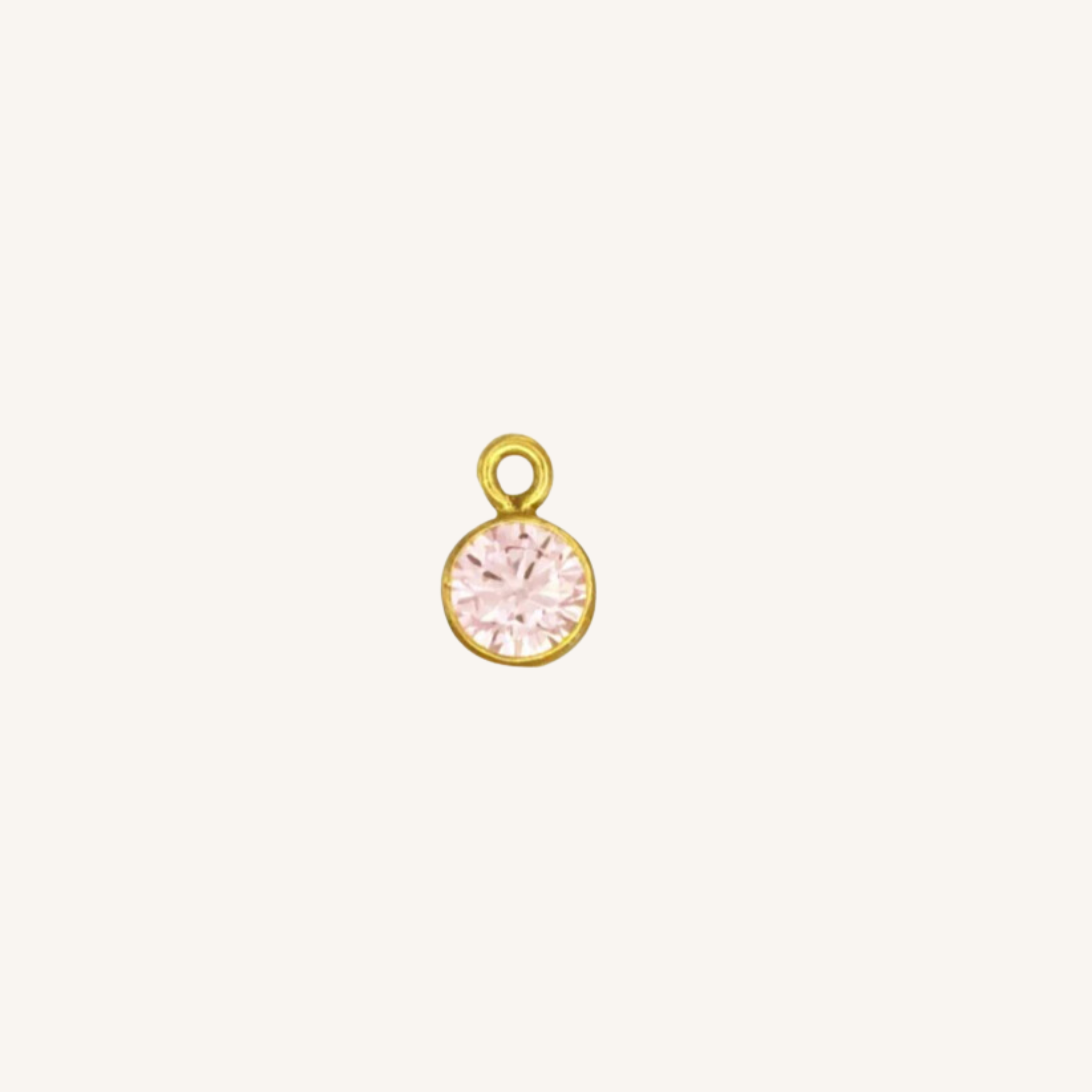 Round tourmaline charm in gold on white backround.