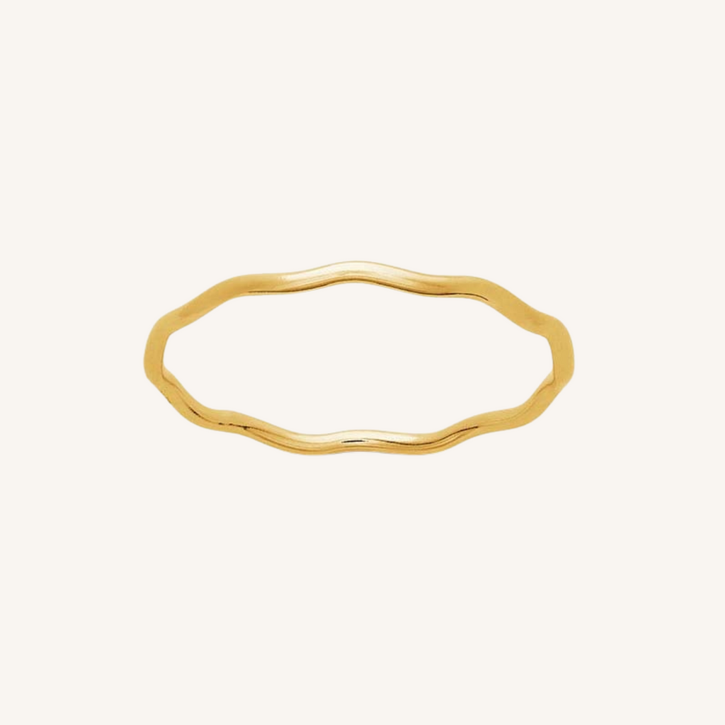 Gold ring with wavy design on a white background