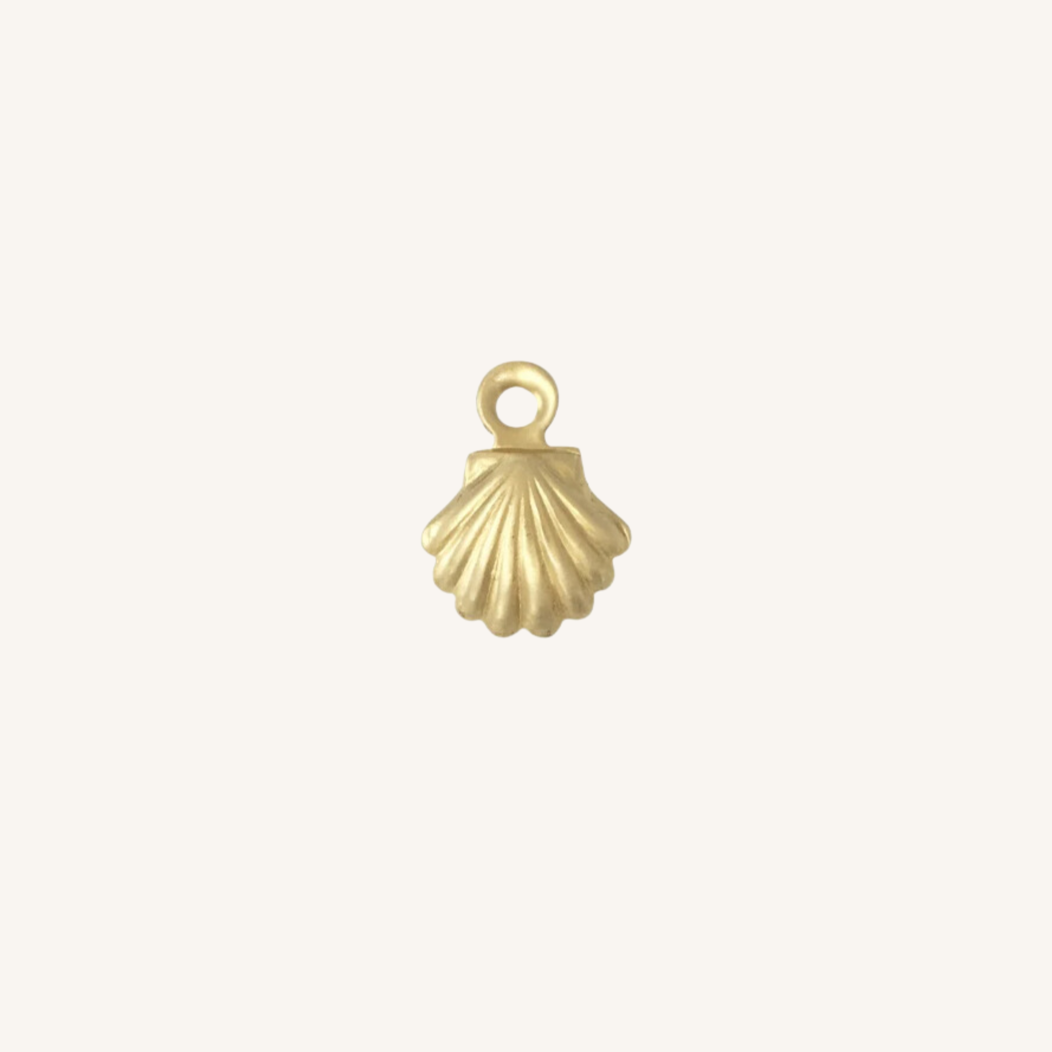A small gold shell-shaped charm with a loop at the top, centered on a plain off-white background.