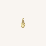 A small gold shell-shaped charm with a loop at the top, centered on a plain off-white background.