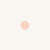 A small round rose gold disc charm with a hole at the top, centered on a plain off-white background.