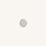 A small round silver disc charm with a hole at the top, centered on a plain off-white background.