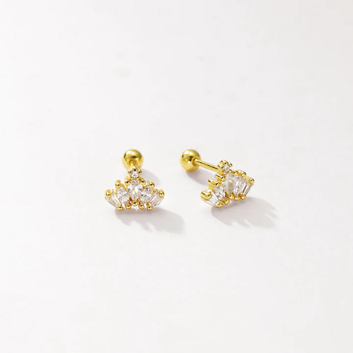 A pair of gold-toned stud earrings with clear gemstones, displayed on a clean off-white background.