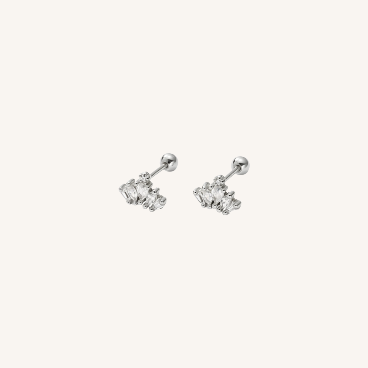 A pair of silver-toned labret earrings with small clear gemstone clusters, shown on a plain off-white background.