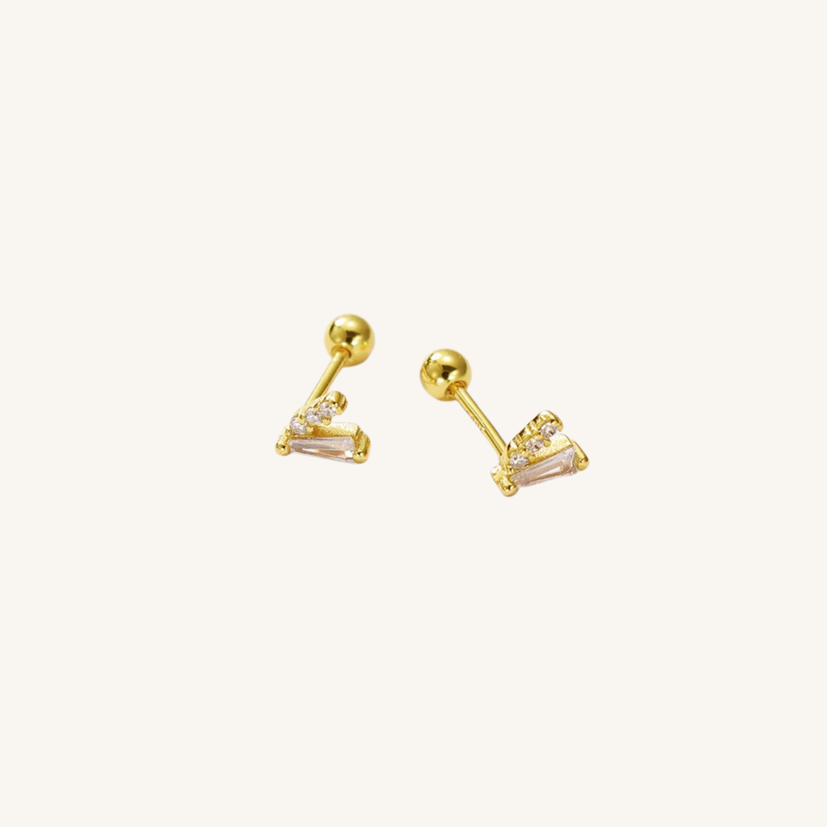 A pair of gold-toned stud earrings with a triangular cluster design featuring clear rectangular cut stones, shown on a plain off-white background.