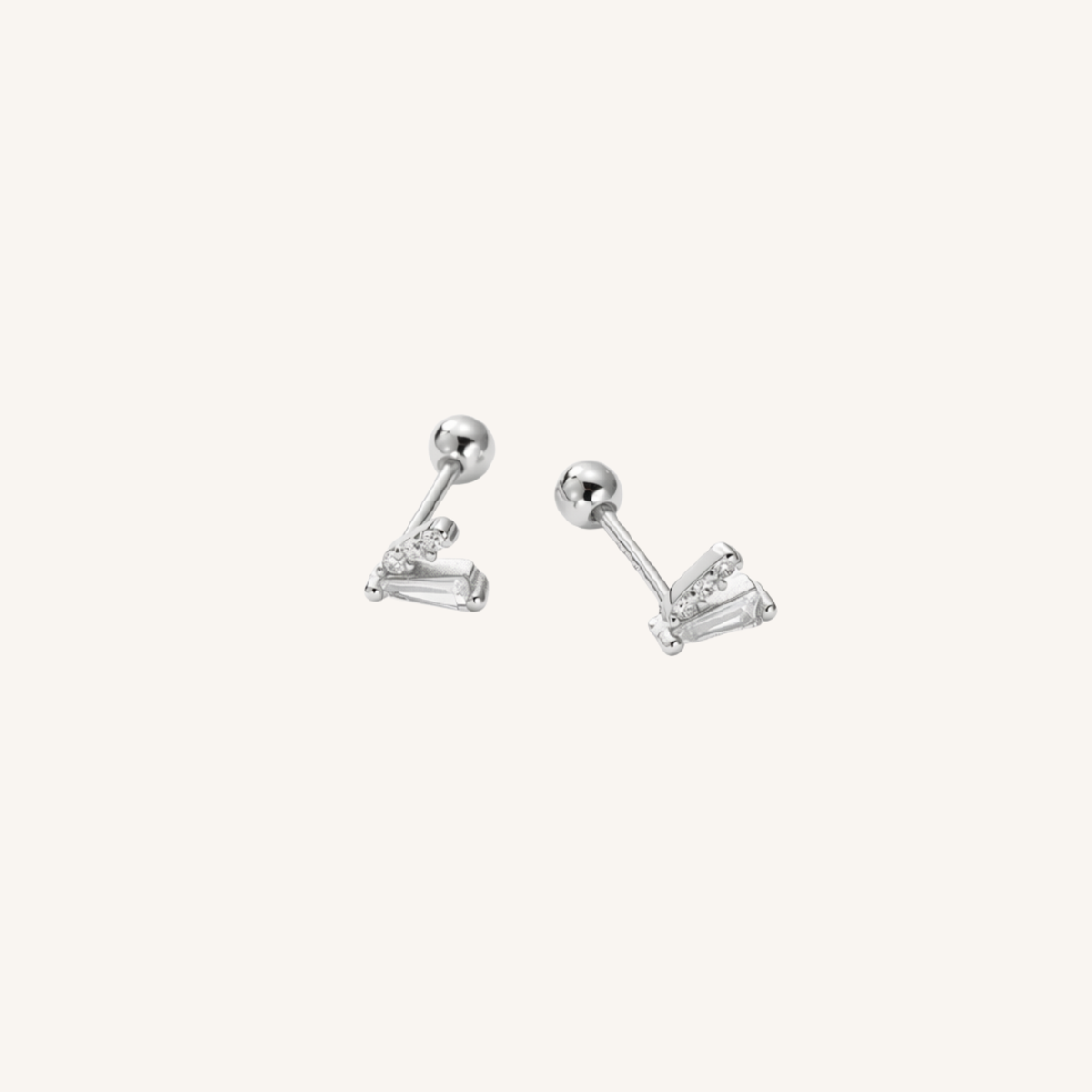 A pair of silver-toned stud earrings with a ball post and a small cluster of baguette-cut clear stones, shown on a plain off-white background.