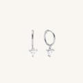 A pair of silver huggie hoop earrings with dangling triangular charms, shown on a plain off-white background.