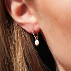 Model Wearing Tilly gold hoop earrings with pearl drops. 