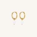 Gold hoop earrings with pearl drops on a white background