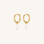 Gold hoop earrings with pearl drops on a white background