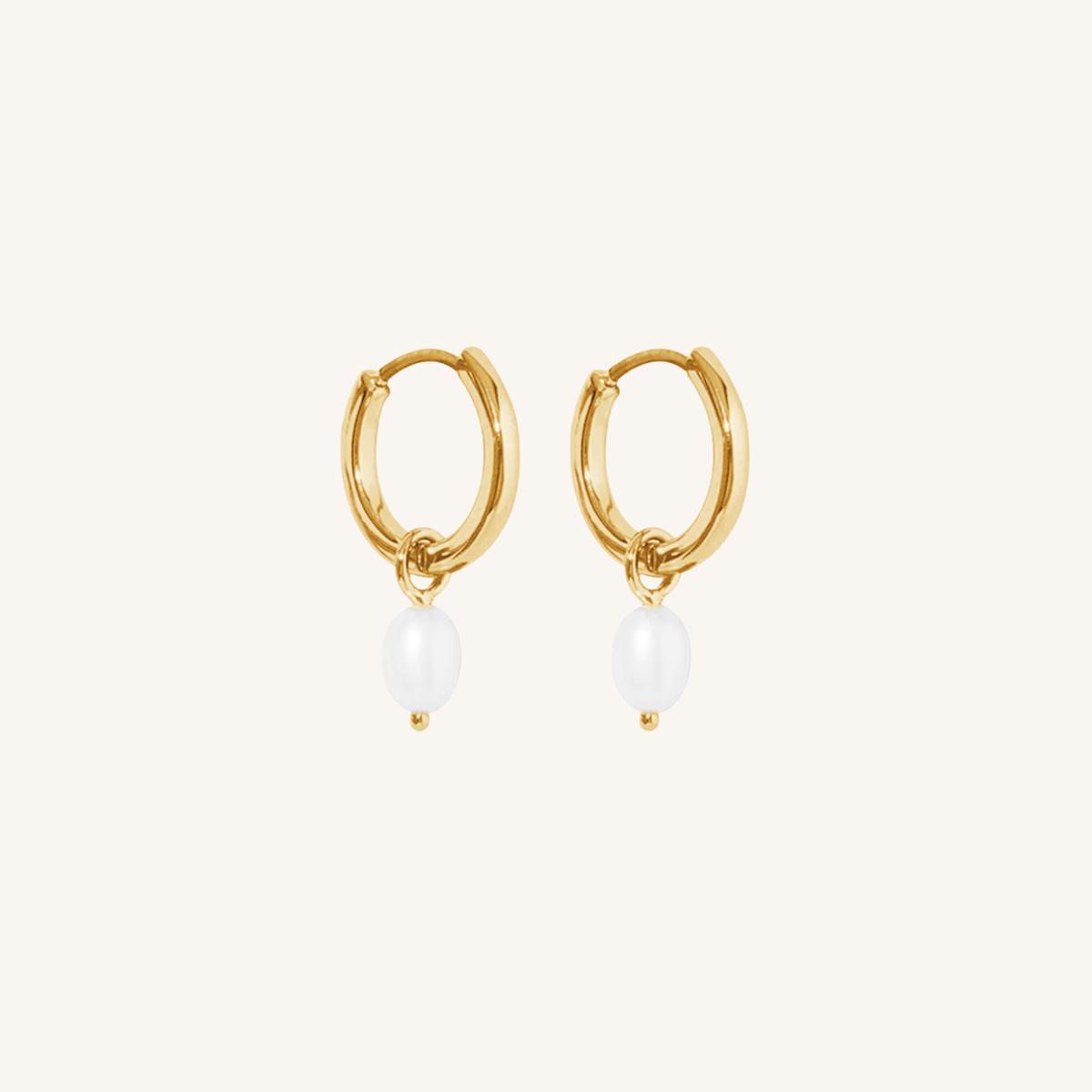 Gold hoop earrings with pearl drops on a white background