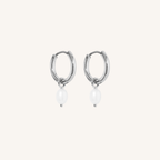 Silver hoop earrings with white pearls on a light beige background