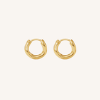 Gold hoop earrings on a light beige background