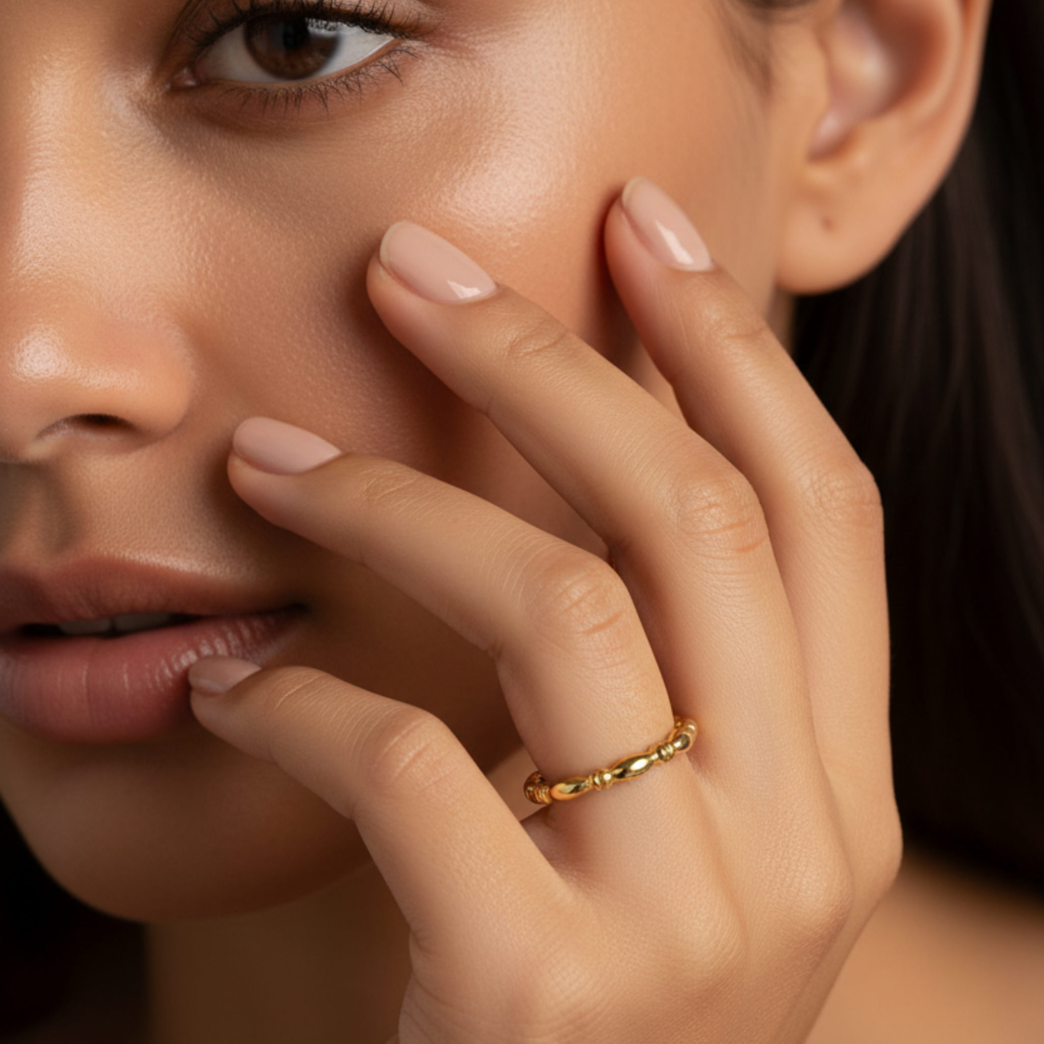 Model wearing the Odessa Ring in 14k gold fill, a beaded stretch band with ridged detailing, shown horizontally on a neutral background
